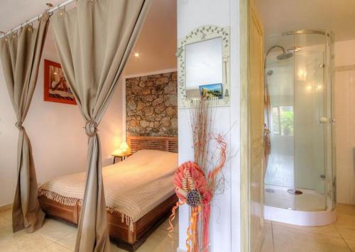 a bedroom with a canopy bed and a shower at Appartement confortable à Moltifao, vue sur montagne, 50 m² in Moltifao