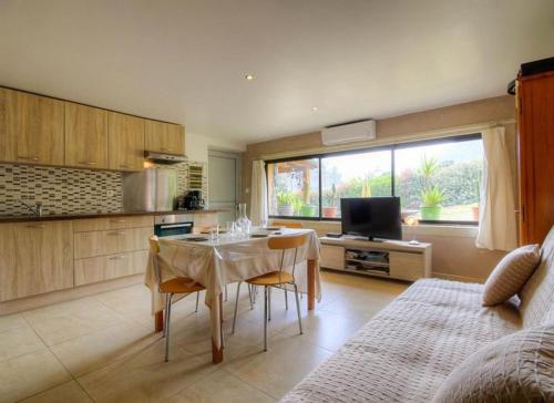 a kitchen with a table and chairs in a room at Appartement confortable à Moltifao, vue sur montagne, 50 m² in Moltifao