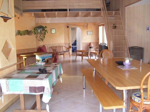 a living room with wooden tables and chairs at Villa ensoleillée à Saint Hilaire de Riez avec piscine privée in Saint-Hilaire-de-Riez