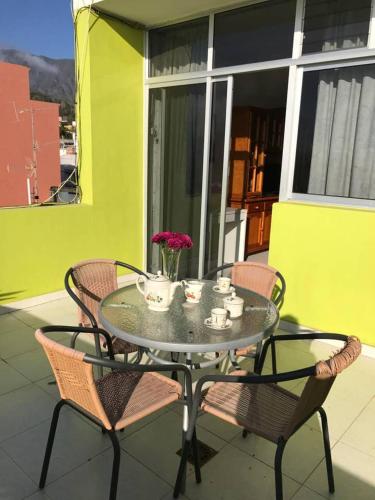 a glass table and chairs on a patio at Welcoming apartment with mountain view in El Paso
