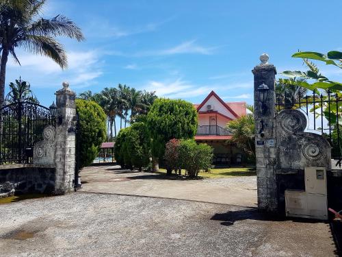 a gate in front of a house with palm trees at Villa charmante à Saint-Benoît avec piscine privée in Saint-Benoît