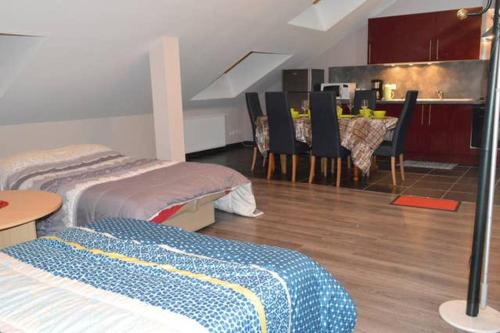 a room with two beds and a table with chairs at Appartement chaleureux à Gérardmer avec parking privé. in Gérardmer