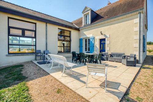 a patio with chairs and a table in front of a house at Maison confortable avec piscine à Villentrois-Faverolles 250m² in Faverolles