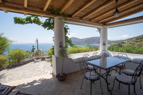 a patio with a table and chairs and a view of the ocean at Charming House in Lipari with Sea View in Lipari