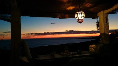 a chandelier hanging from a porch with a view of the ocean at Charming house with sea and mountain views in El Chaparral in EL Chaparral