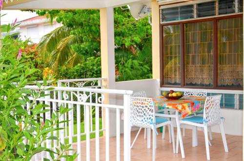 a porch with a table and chairs on it at Studio cocooning à Saint Anne / 27 m² / jardin fleuri in Sainte-Anne