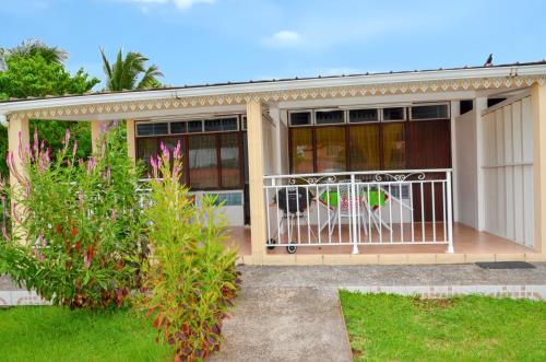 a house with a balcony with a dog in it at Studio cocooning à Saint Anne / 27 m² / jardin fleuri in Sainte-Anne