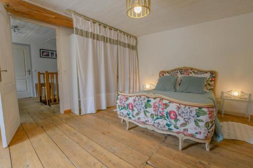 a bedroom with a bed with a floral bedspread at Les loulous in Arrentières