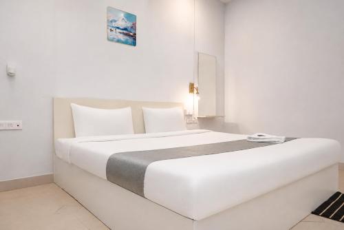 a white bedroom with a large white bed at Fly Inn in Guwahati