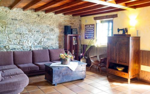 a living room with a couch and a stone wall at Luxurious Villa in Outeiro - Private Pool in Santa María La Mayor del Rosario
