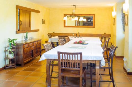 a dining room with a white table and chairs at Luxurious Villa in Outeiro - Private Pool in Santa María La Mayor del Rosario