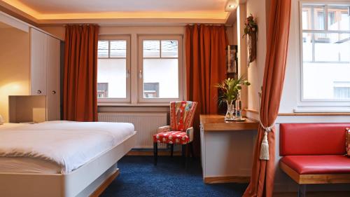 a hotel room with a bed and a chair at Rhein Hotel Bacharach und Stübers Restaurant in Bacharach