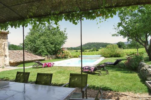 a patio with a table and chairs and a swimming pool at Villa spacieuse à Oppède avec piscine et vue imprenable in Oppède