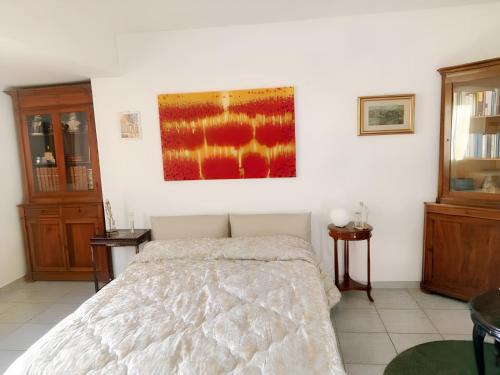 a bedroom with a bed and a painting on the wall at Charming Apartment in Vibo Valentia with Terrace, 60 m² in Vibo Valentia