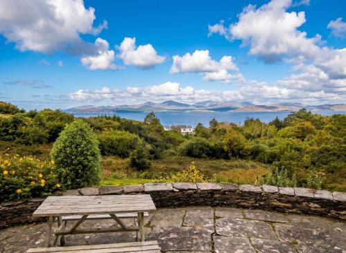 a wooden picnic table sitting on top of a hill at Spacious house with sea and mountain views, Co. Kerry in Kells
