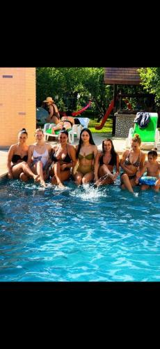 a group of women sitting in a swimming pool at Hanul Marioarei in Buneşti