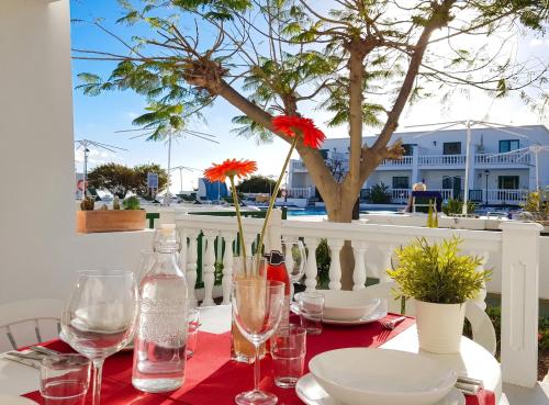 a table with plates and glasses and flowers on it at Charming Apartment in Tías + Pool in Tías