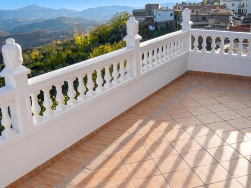 a balcony with a white railing and mountains in the background at Idyllic House in Yegen with Mountain View in Yegen