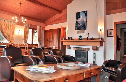 a room with chairs and a table and a fireplace at Chalet spacieux à Cordon 180 m² avec vue montagne in Cordon