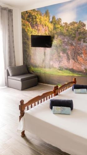 a living room with two beds and a flat screen tv at Comfortable Studio in Sumartin with Sea View - 22 m² in Sumartin
