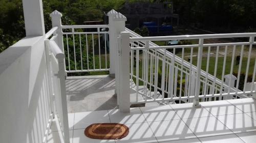 a white fence on a balcony with a wicker basket at Appartement charmant à Petit-Canal in Petit-Canal