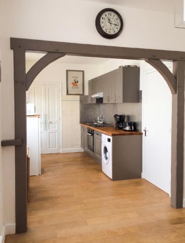 a kitchen with a clock on the wall at Maison chaleureuse à Erquy avec jardin et parking in Erquy
