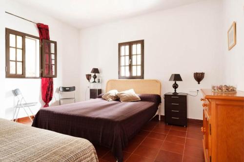 a bedroom with a bed and two windows at Spacious Villa in Conil de Frontera with Private Pool in Roche