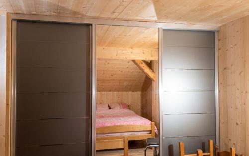 a small bedroom with a bed in a cabin at Studio confortable à Taninges, 25 m² avec vue sur jardin in Taninges
