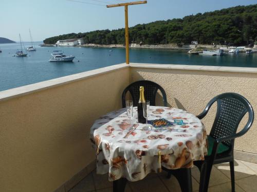 a table on a balcony with a view of the water at Sea View Apartment in Prvić Luka, 46m², Terrace in Prvić Luka