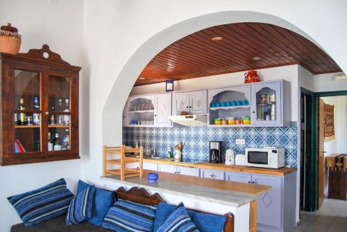 a kitchen with a couch and a counter with a microwave at Picturesque Villa in Limnos + Enclosed Garden + Sea View in Lemnos