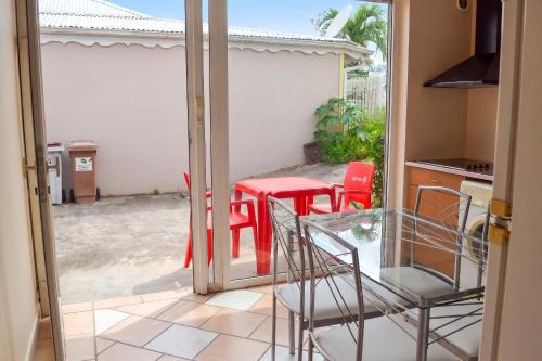 a glass door leading to a patio with a table and chairs at Appartement confort au Diamant 25 m² terrasse in Le Diamant