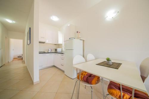 a kitchen with a white refrigerator and a table at Bright Apartment in Vrsi with Terrace and Garden, 65 m² in Vrsi
