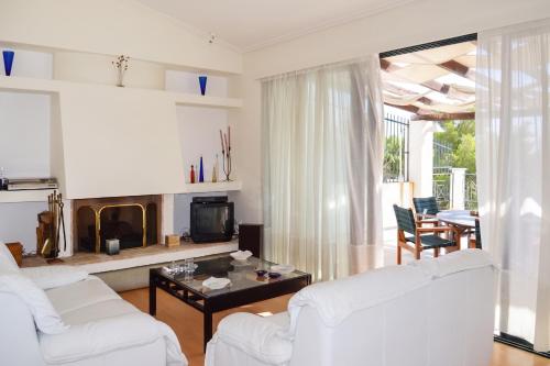 a living room with two white couches and a fireplace at Charming Villa with Sea View in Karistos in Karistos