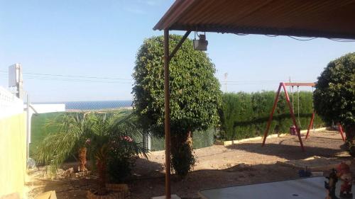 a view of a playground with a swing at House with private pool in Aguilas, sea & pool view in Águilas