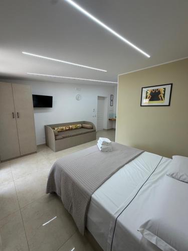 a bedroom with a large bed and a couch at Luxury Room Home Serpico in Scisciano