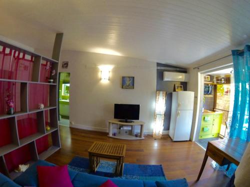 a living room with a couch and a refrigerator at Studio charmant Le Moule 35m² + balcon in Le Moule