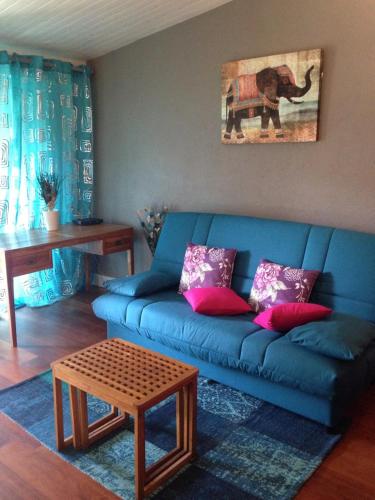 a living room with a blue couch and a table at Studio charmant Le Moule 35m² + balcon in Le Moule