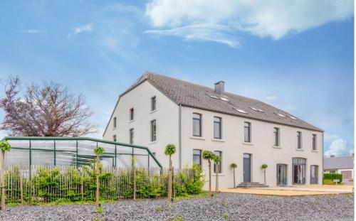 a white house with a fence in front of it at Spacious villa in Florenville with private pool in Florenville