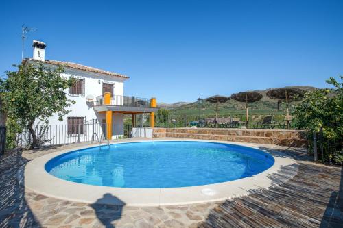 a swimming pool in front of a house at Comfortable House in Carcabuey with Private Pool in Carcabuey