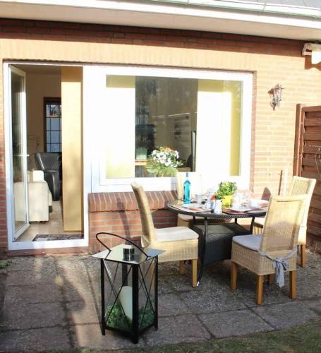 a patio with a table and chairs and a window at Spacious House in Sylt-Ost, Garden in Tinnum