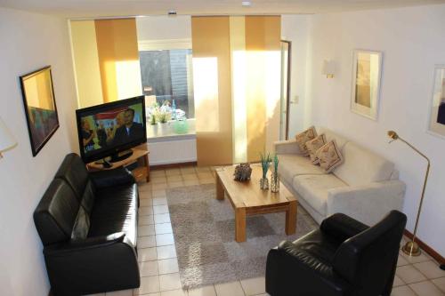 a living room with a couch and chairs and a tv at Spacious House in Sylt-Ost, Garden in Tinnum