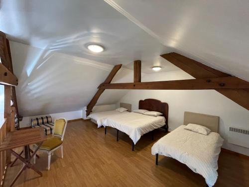 a attic room with two beds and a desk at Cottage Normand in Lison