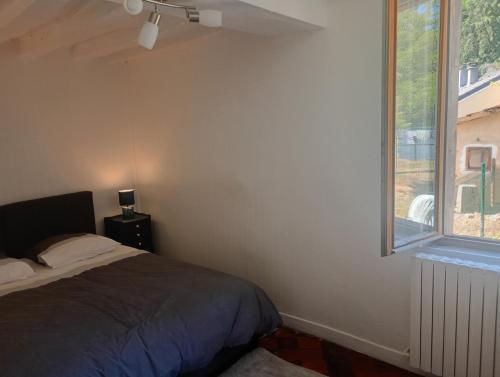 a bedroom with a bed and a window at La maisonnette Poyaudine in Toucy
