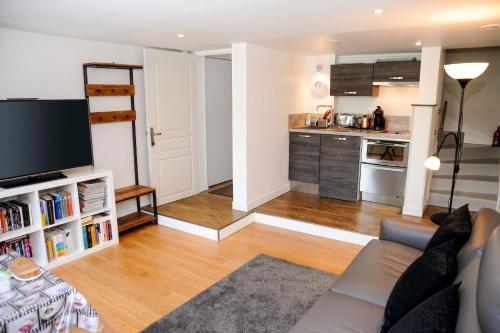 a living room with a couch and a kitchen at Appartement contemporain à Cognac, 50 m² - Parking. in Cognac