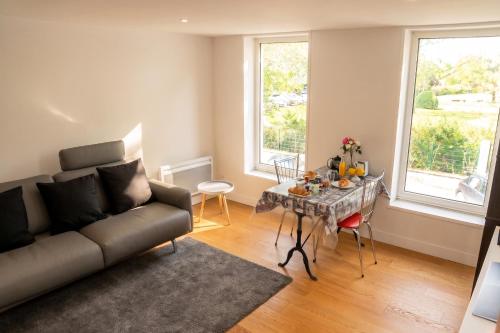 a living room with a couch and a table at Appartement contemporain à Cognac, 50 m² - Parking. in Cognac