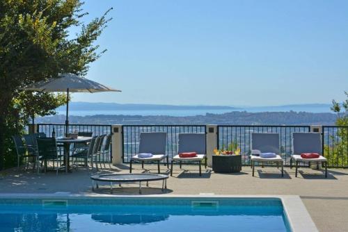 a swimming pool with chairs and tables and an umbrella at Family Villa in Solin with Pool in Solin