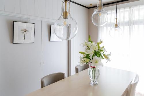 a dining room with a table with flowers in a vase at HABi-Sekido5 in Wakayama