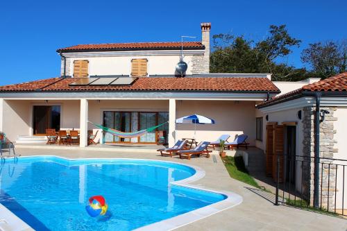 a swimming pool in front of a house at Charming Villa near Žminj with Private Pool in Žminj