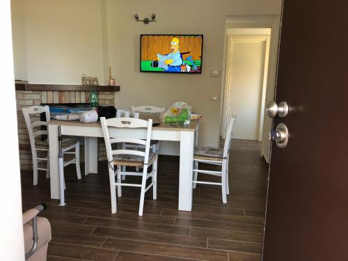 a dining room with a white table and chairs at Cozy house in Chieti with private garden in Chieti