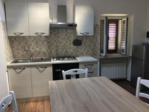 a kitchen with a table and a sink and a stove at Cozy house in Chieti with private garden in Chieti
